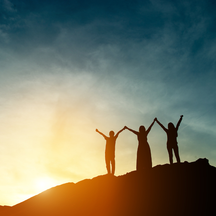 Three people on hill celebrating