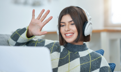 Lady waving at her computer screen